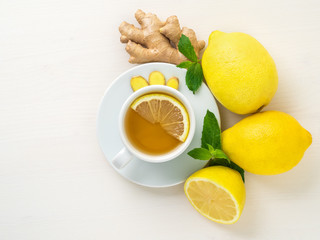 Folk ways to treat colds -  cup of tea and a slice of lemon, ginger, mint, whole lemons and half on...