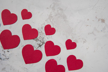 Red paper hearts on a white texture background, copy space