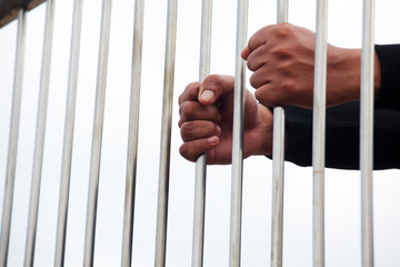hands of prisoner in jail with white background