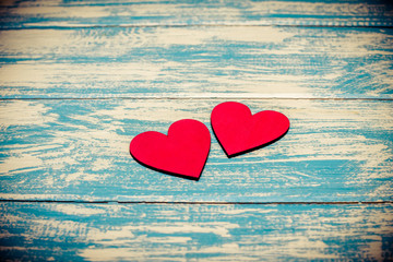 Fototapeta premium Two red hearts lie on the wooden background 