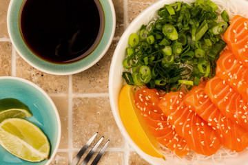 Hawaiian Poke Bowl Of Salmon Sashimi With Rice Noodles And Spring Onions