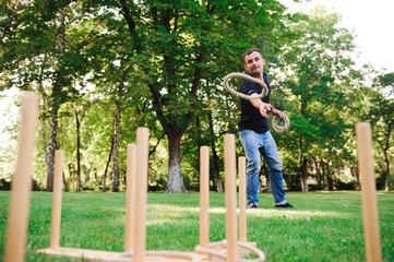 Obraz premium Boy playing a game throwing rings outdoors in summer park