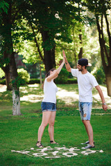 Fototapeta premium A young couple celebrate victory playing tic-tac-toe in the park