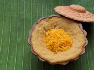 Thai dessert, egg custard with sweet sticky rice topped with golden threads, on banana leaf background