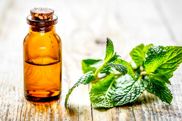 organic cosmetics with herbal extracts of mint on wooden backgro