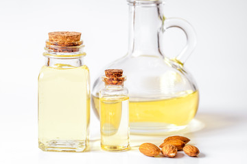 cosmetic almond oil in glass bottle on white background