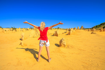 Western Australia travel freedom concept. Carefree woman with open arms watching the desert of Pinnacles limestone in Nambung National Park of Cervantes, in WA state of Australia