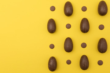 Chocolate easter eggs on a bright yellow background. Easter holiday concept