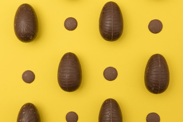 Chocolate easter eggs on a bright yellow background. Easter holiday concept