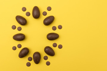 Chocolate easter eggs on a bright yellow background. Easter holiday concept