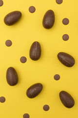 Chocolate easter eggs on a bright yellow background. Easter holiday concept