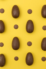 Chocolate easter eggs on a bright yellow background. Easter holiday concept