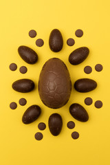 Chocolate easter eggs on a bright yellow background. Easter holiday concept
