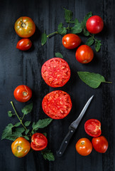 Beautiful tomatoes on the dark wooden table 
