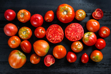 Beautiful tomatoes on the dark wooden table 