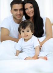 Fototapeta premium Happy couple and son sitting in bed