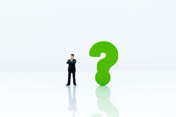 Miniature people : Businessman and question mark. Image use for find answers, solution, business concept.