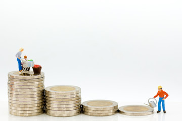 Miniature people: Merchants are watering down on higher coins. Image use for growing retail markets, business concept.