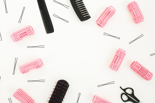 Hairdresser tools - combs, curlers, and hair clips on white background. Beauty composition. Frame with copy space. Flat lay, top view