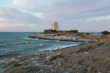 View of Vieste coast, Italy, with blue sea and an old defense tower.