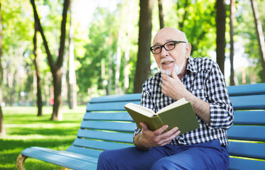 Fototapeta premium Elderly man in casual reading outdoors