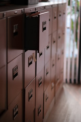 Focus on the opened drawer of file cabinet. 