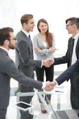 Happy smiling businessmen handshaking after signing contract .