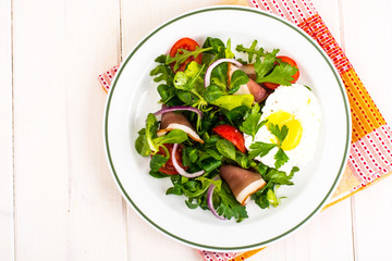 Fresh vegetable salad with ham and fried egg