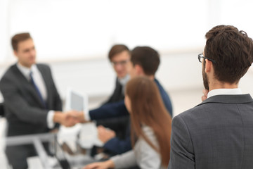 Businessmen making handshake in an office.