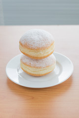 Two sweet Polish paczek on a dessert.
