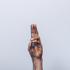 Female golden hand with white manicure
