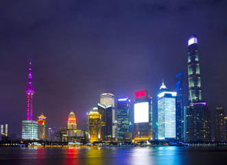 Obraz premium Modern city skyscrapers of Shanghai skyline at night with reflection of beautiful ligth in Huangpu river view from the bund, Shanghai, China