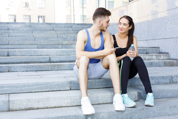Woman and man choose music to listen during jogging