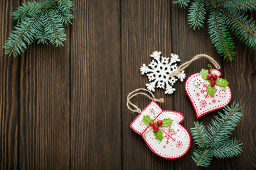 Christmas or New Year background. Fir-tree branches, different tree toys with  Christmas ornament on dark brown wooden background. Selective focus. Top view. Copy space.