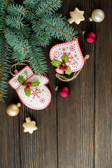 Christmas or New Year background. Fir-tree branches, different tree toys with  Christmas ornament on dark brown wooden background. Selective focus. Top view. Copy space.