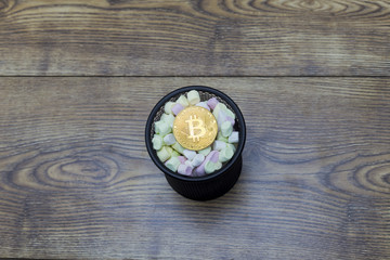 Gold bitcoin coin and colorful sweets