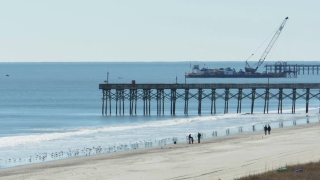 People Walking Next To Fishing Pier At Myrtle Beach SC In Winter, 4K