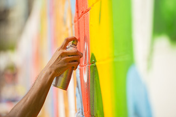 
hand spraying  to paint the street art on wall.