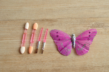 A set of small make up brushed displayed with a silk butterfly