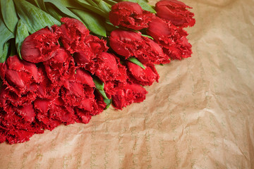 Fresh flower composition, bouquet red tulips on craft paper background. Valentine, Women's, 8 march, birthday, mother's day present. Copy space, close up, front view.