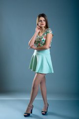 woman dressed in green dress over blue grey background