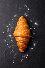 Fresh croissant Black slate background. Top view