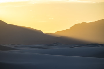 Obraz premium sunlight pouring over a mountain with beautiful sand dunes below