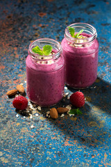 berry smoothie in a bottle and dark background, vertical