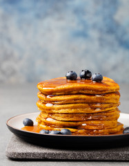 Pumpkin pancakes with maple syrup and blueberries