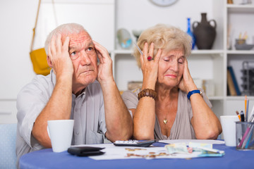 Upset retired couple calculating domestic finances