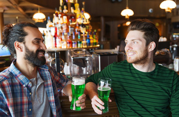 male friends drinking green beer at bar or pub