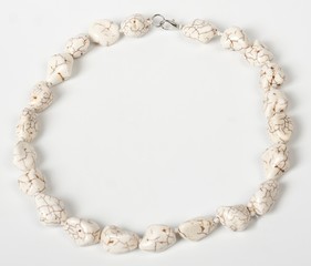 Fototapeta premium Necklace with stones on a white background. Bijouterie. Women's accessories. Necklace on the neck. Valuable jewelry.Decorating for women.Women's accessories isolated white background