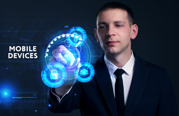 Business, Technology, Internet and network concept. Young businessman working on a virtual screen of the future and sees the inscription: Mobile devices