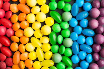 Rainbow colorful candies background over grey backdrop